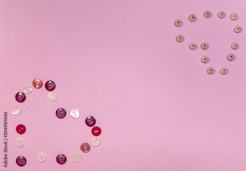 Composition for Valentine's Day February 14th. Button heart and wooden beads on a delicate pink background. Greeting card. Flat lay, top view, copy space.