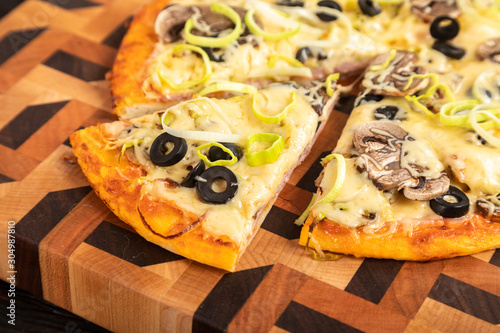 Sliced a pizza served on wooden cutting board