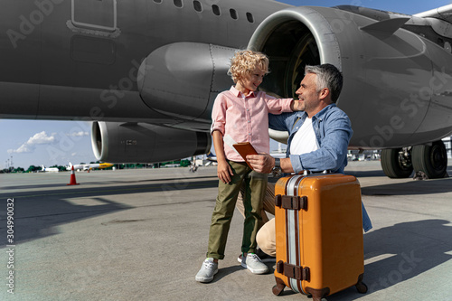 Smiling little boy is looking at his parents before trip