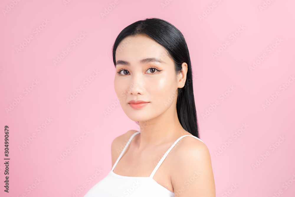 Portrait of young Asian woman with perfect skin on pink background. Concept of natural cosmetics and skincare. Portrait of young Asian woman with perfect skin on pink background. Concept of natural cosmetics and skincare.