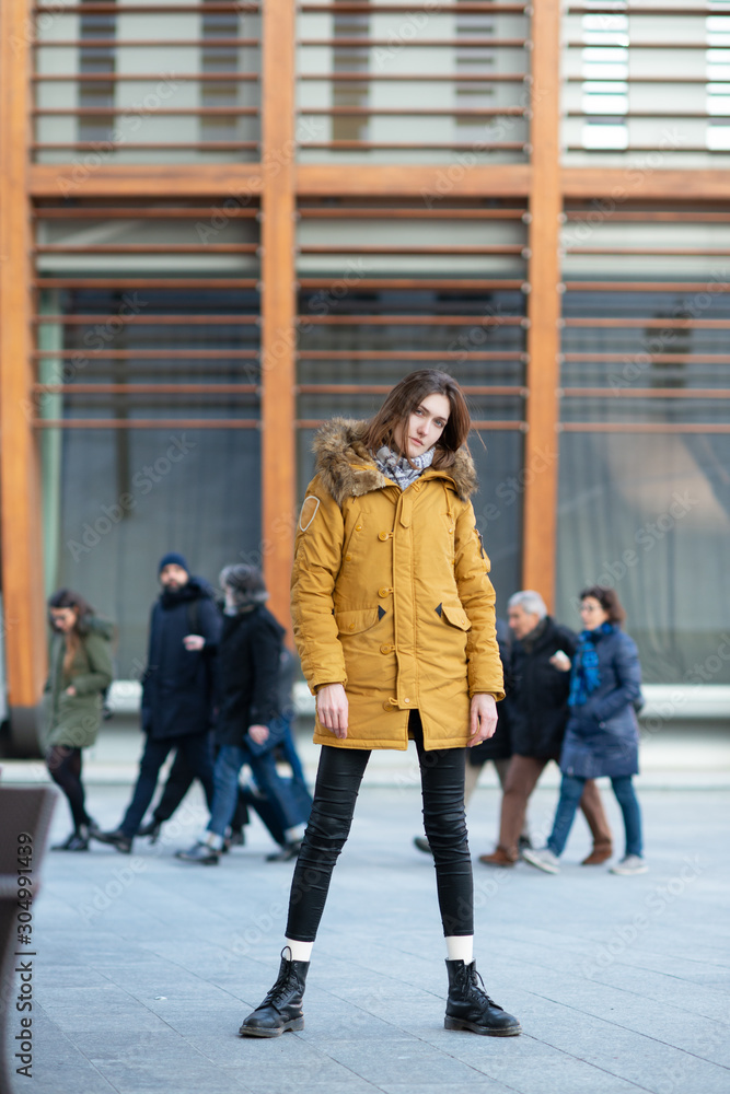 Obraz premium Fashion model walking and posing outdoor. Young blond caucasian woman posing winter outdoo. Beautiful girl, urban portrait in Milan, Italy