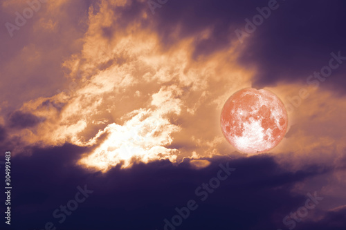 full harvest moon back on silhouette cloud on sunset sky