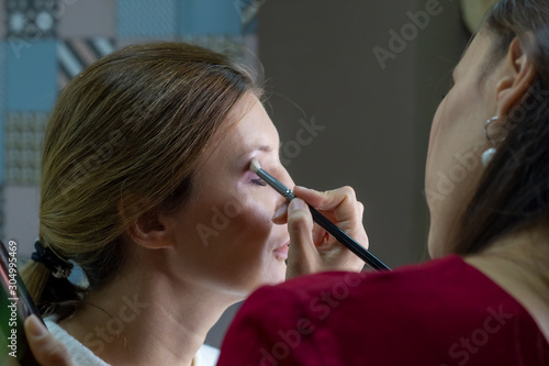 Make-up artist puts shadows on the face close-up