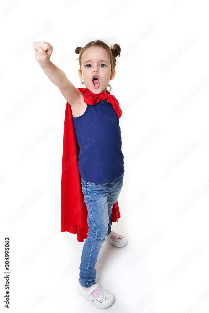Adorable little girl flying like a superhero in blue t-shirt and red mantle. Super girl. The new generation saves the world. Good triumphs over evil. Funny kid portrait