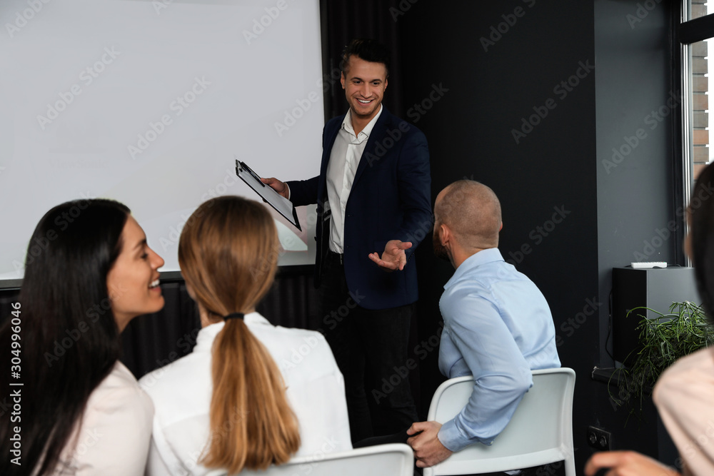 Business people at seminar in conference room with video projection screen Business people at seminar in conference room with video projection screen