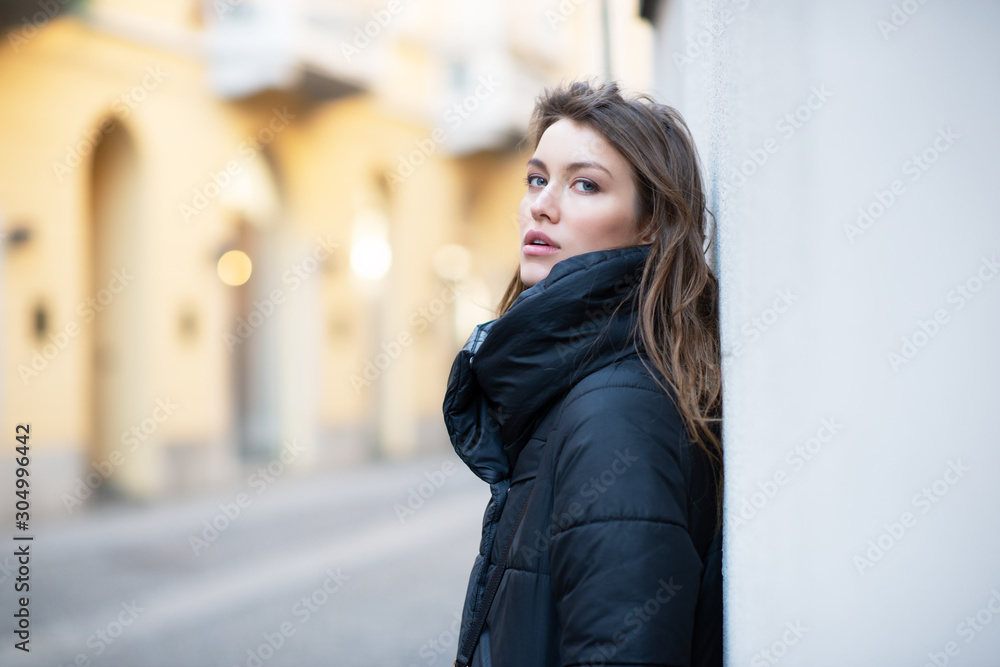 Young caucasian woman dressed in black clothes. Beautiful caucasian girl posing outdoor in Milan, Italy. Street fashion, winter outdoor Young caucasian woman dressed in black clothes. Beautiful caucasian girl posing outdoor in Milan, Italy. Street fashion, winter outdoor