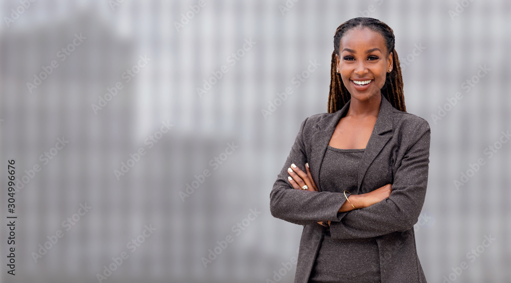 Wide banner panorama portrait of African American CEO real estate business woman standing confident, smiling, with arms folded, copy space Wide banner panorama portrait of African American CEO real estate business woman standing confident, smiling, with arms folded, copy space