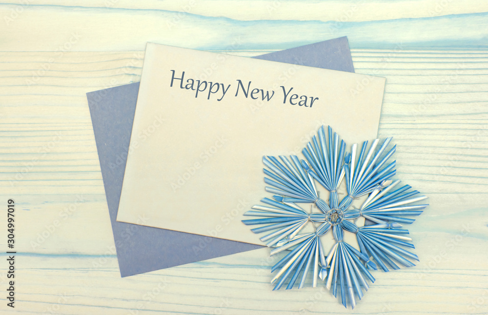 Happy New Year 2020! Top view of blank christmas card with handmade snowflake on a wooden background. Christmas background in natural tones. Happy New Year 2020! Top view of blank christmas card with handmade snowflake on a wooden background. Christmas background in natural tones.