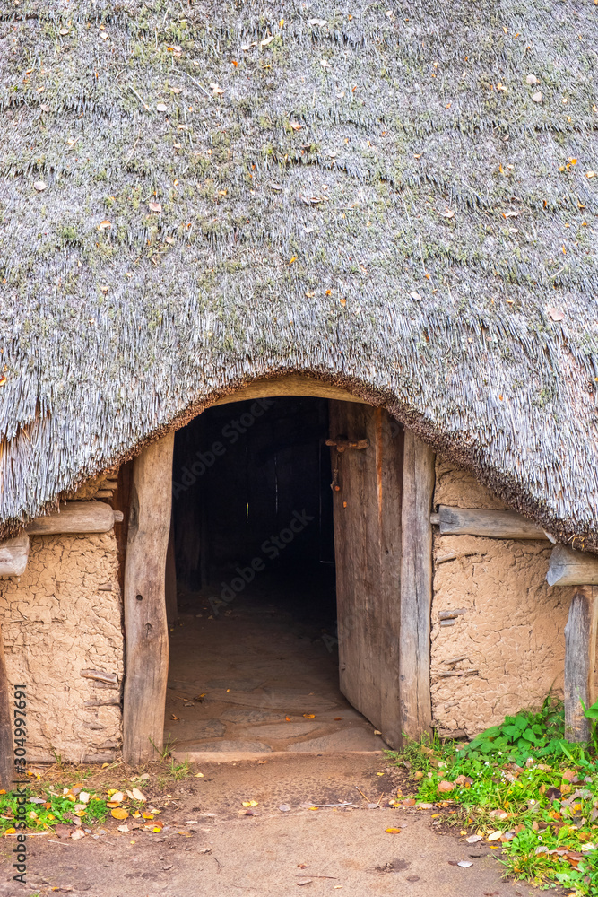 Doorway to an old hut with thatched roof