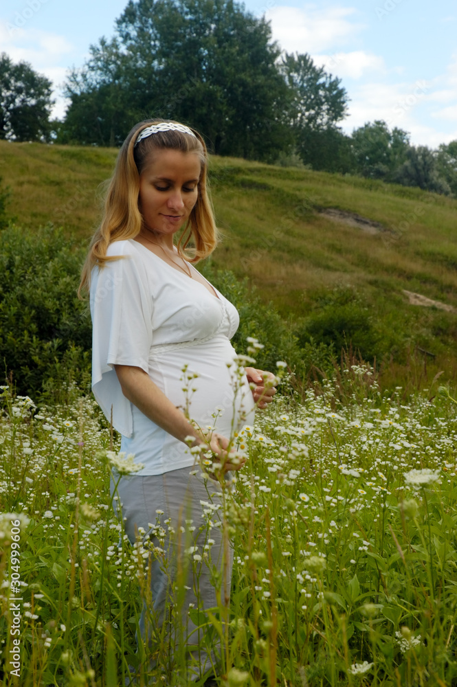 Beautiful pregnant woman relaxing outside in the park Beautiful pregnant woman relaxing outside in the park