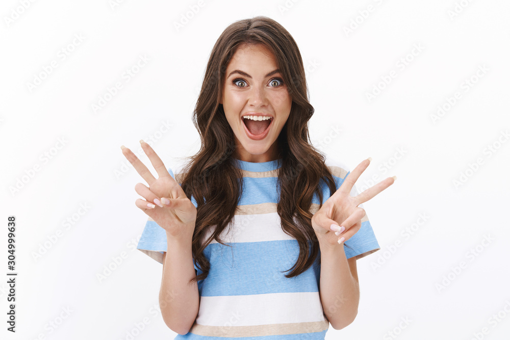 Ambitious cheerful glamour brunette woman looking impressed and joyful, show peace or victory signs entertained, enjoy vacation summer holiday trip, stand upbeat smiling happily, white background Ambitious cheerful glamour brunette woman looking impressed and joyful, show peace or victory signs entertained, enjoy vacation summer holiday trip, stand upbeat smiling happily, white background