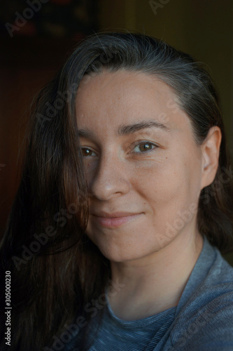 Portrait of a woman without makeup with a little gray hair