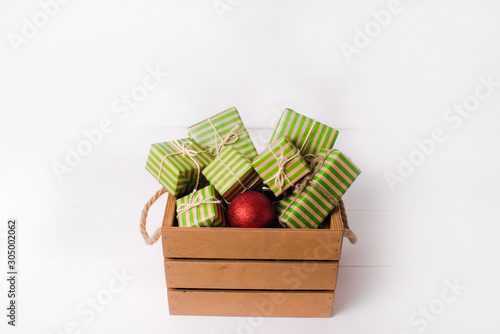 Christmas background with gift boxes and pine branch on a white wooden background.