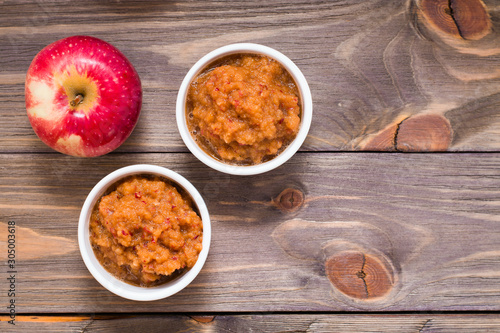 Tableau sur toile Fresh applesauce in bowls and red apples on a wooden table