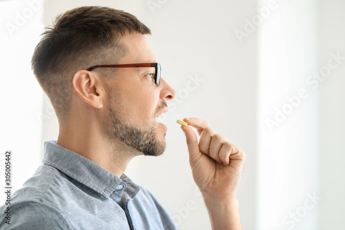 Man taking pill at home