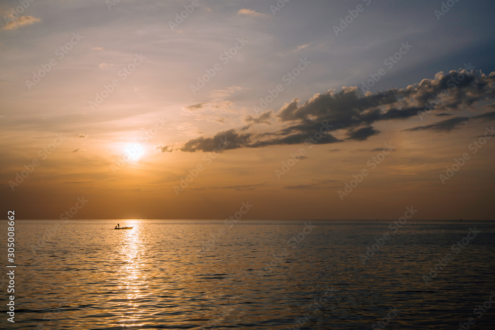 Amazing summer sunset view on the beach. Beautiful blazing sunset landscape at black sea and orange sky above it with awesome sun golden reflection on calm waves as a background.