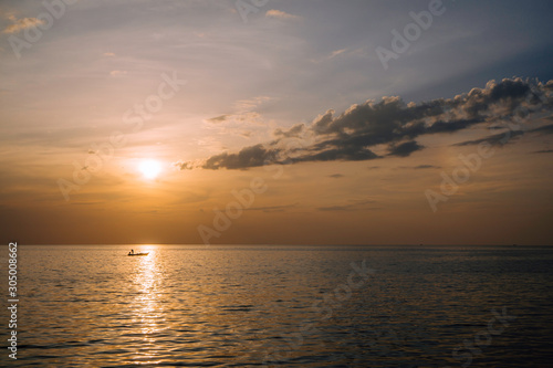 Amazing summer sunset view on the beach. Beautiful blazing sunset landscape at black sea and orange sky above it with awesome sun golden reflection on calm waves as a background.