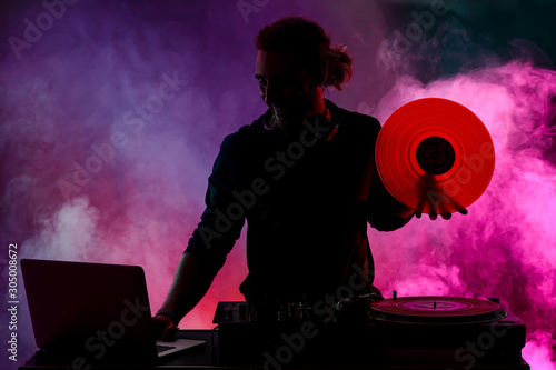 Silhouette of male dj playi...