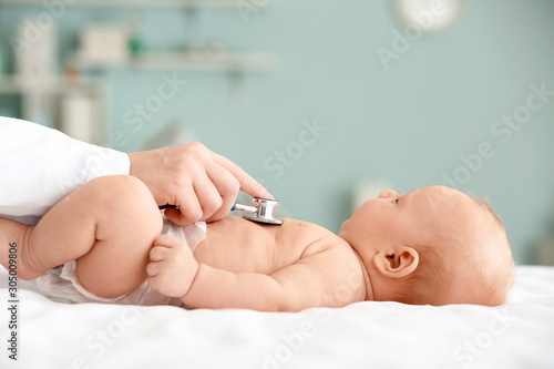 Pediatrician examining cute baby in clinic Fototapet