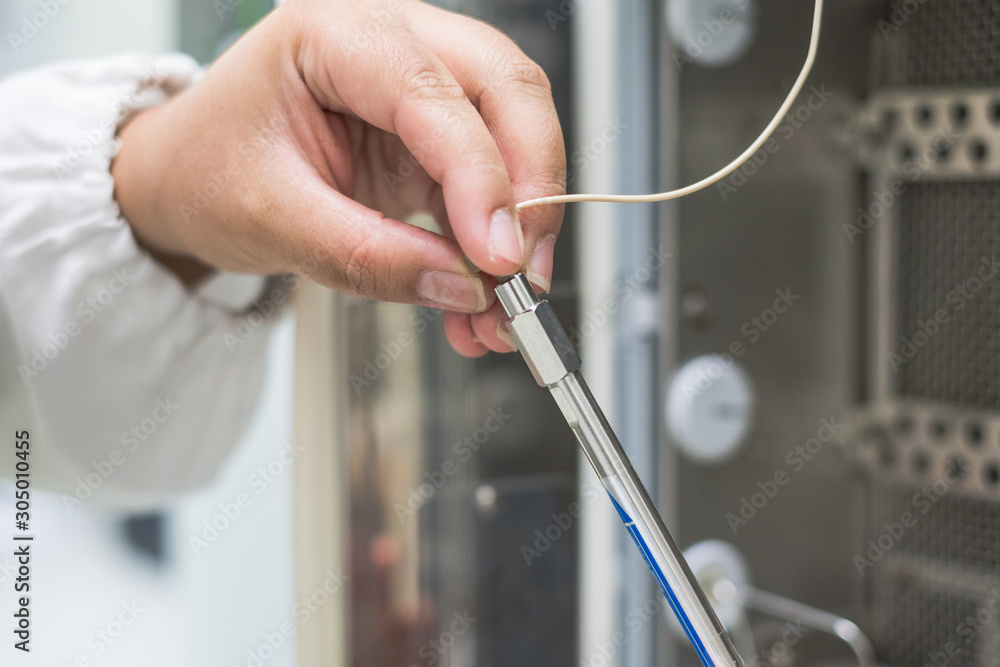 Analyst is working in laboratory with connecting HPLC column to the