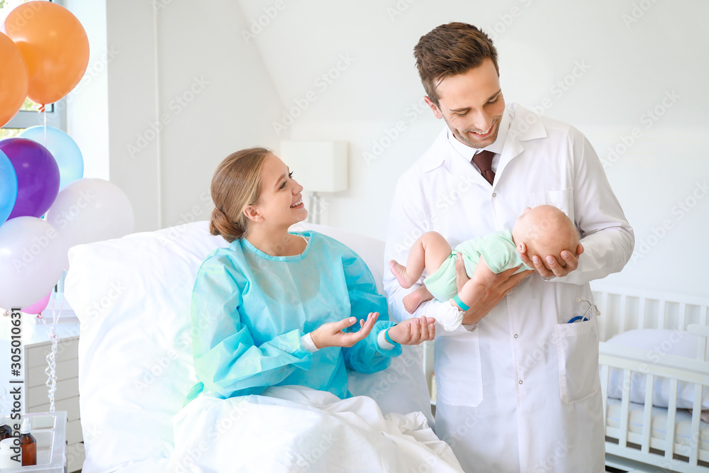 Obraz premium Young woman with newborn baby and gynecologist in maternity hospital