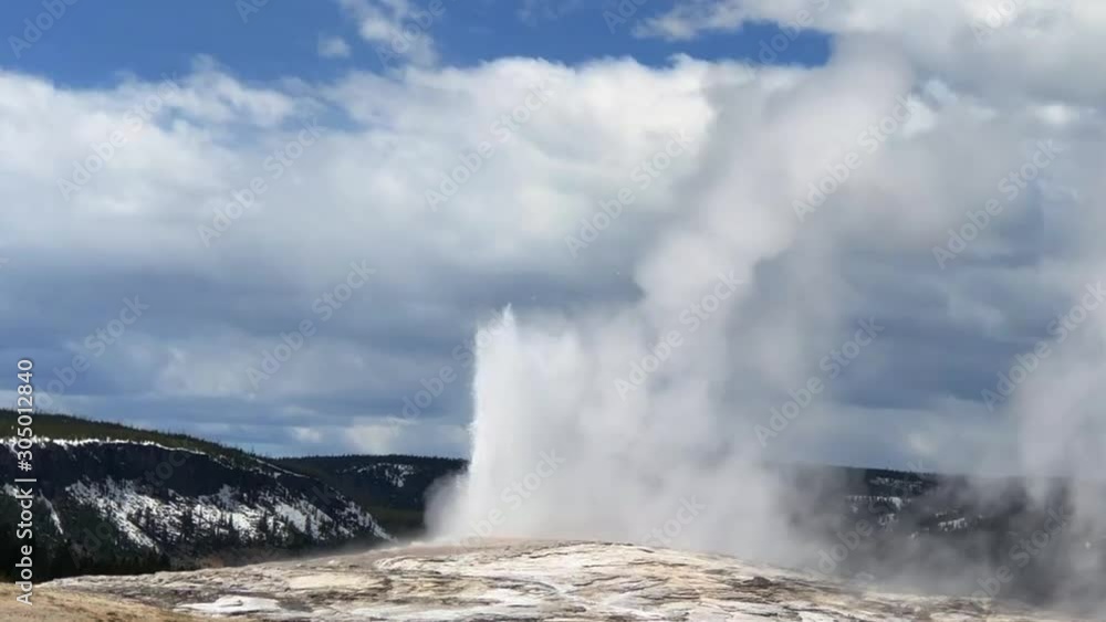 Yellowstone National Park Old Faithful Geyser Eruption on partially cloudy day Yellowstone National Park Old Faithful Geyser Eruption on partially cloudy day