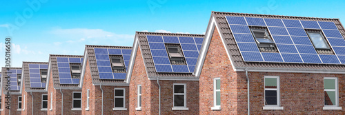 Row of house with solar panels on roof on blue sky background.