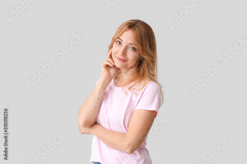 Stylish mature woman on light background