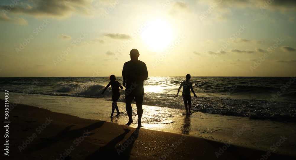 Fototapeta premium Father with two kids enjoying summer vacation on the beach