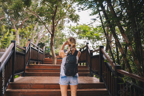 Traveler blonde backpacker woman walking taking photos in tropical forest, Travel adventure nature in China, Tourist beautiful destination Asia, Summer holiday vacation trip, Copy space for banner