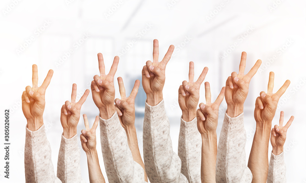 Row of man hands showing victory gesture
