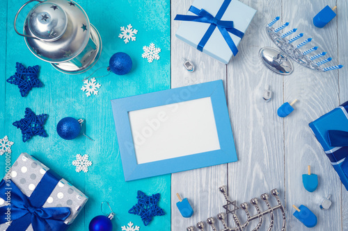 Christmas and Hanukkah celebration concept. Winter holidays background with photo frame, gift boxes and traditional decorations. Top view from above photo