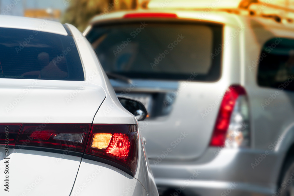 Luxury of white car and open turn signal for prepare for U-Turn on the road with blurred other car on front.