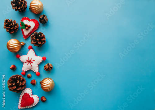 Copyspace flat lay of Soft felt toys like stars, hearts and pine cones on the blue background. New year backgrounds concept. Festive christmas flatlays of decorations concept.