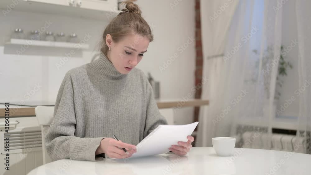 Young Woman Reacting to Failure and reading Documents Young Woman Reacting to Failure and reading Documents