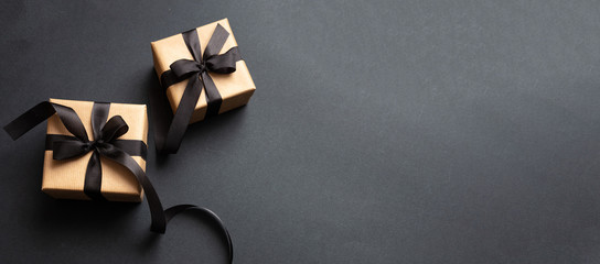Gifts with black ribbon against black background, Black Friday concept.