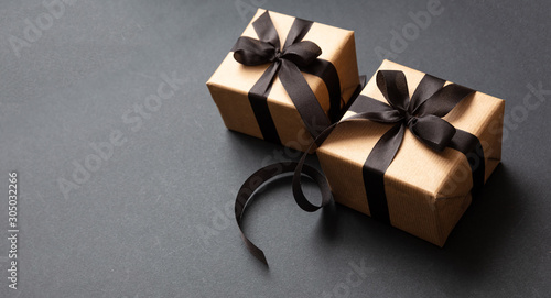 Gifts with black ribbon against black background, Black Friday concept.