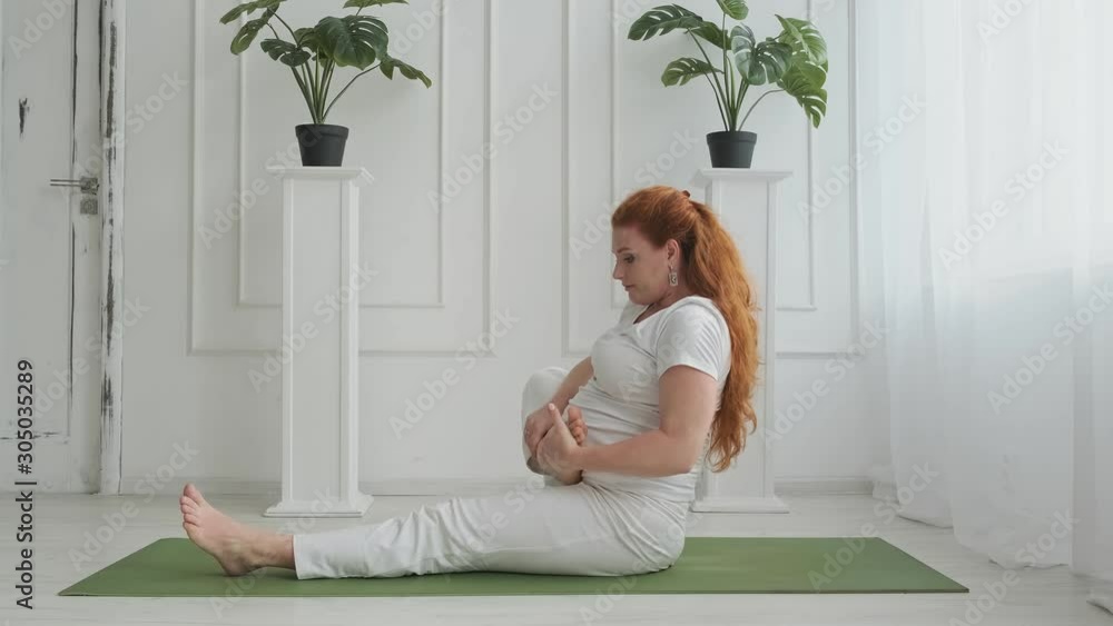 Beautiful pregnant doing yoga on floor at home. Active redhead pregnant woman. Healthcare concept. Young expectant mother practice stretching yoga. Full length shot in 4k, UHD Beautiful pregnant doing yoga on floor at home. Active redhead pregnant woman. Healthcare concept. Young expectant mother practice stretching yoga. Full length shot in 4k, UHD