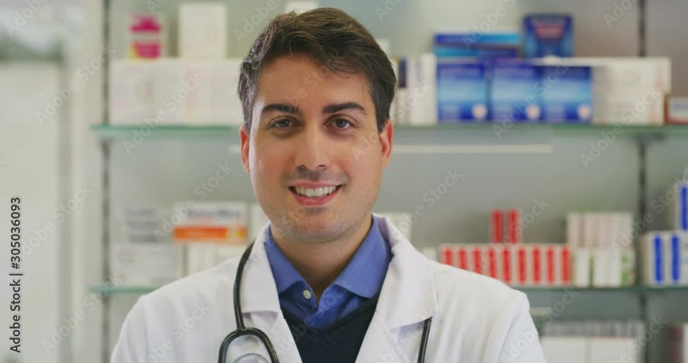 Portrait of an young male pharmacist consultant is smiling in camera in a drug store. Portrait of an young male pharmacist consultant is smiling in camera in a drug store.
