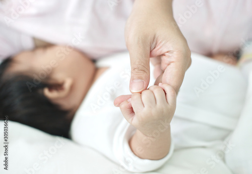Mother holding newborn baby hand and breast feeding on background : Closeup