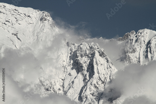 Blick von Innsbruck im Inntal in Tirol auf die Nordkette und die schneebedeckten Gipfel im Winter. Wolken in der Felswand