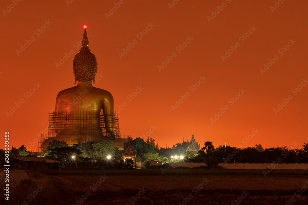 Back view, Big golden buddha in sunrise or sunset time. at Wat Muang in Ang Thong, Thailand.