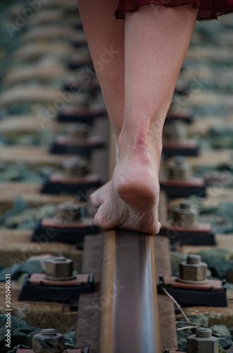 Bare feet walking on the train track