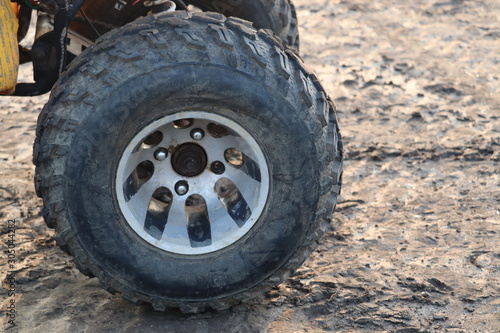 Black rubber tyre of a small tractor or car.
