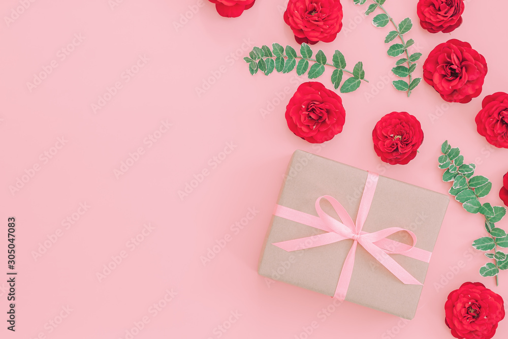 Gift or present box wrapped in kraft paper and rose flower on pi