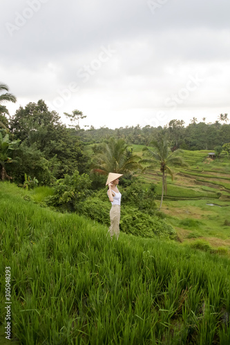 Woman wearing traditionl bamboo hat on the rice field terrace