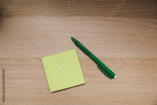 note and pen on wooden background