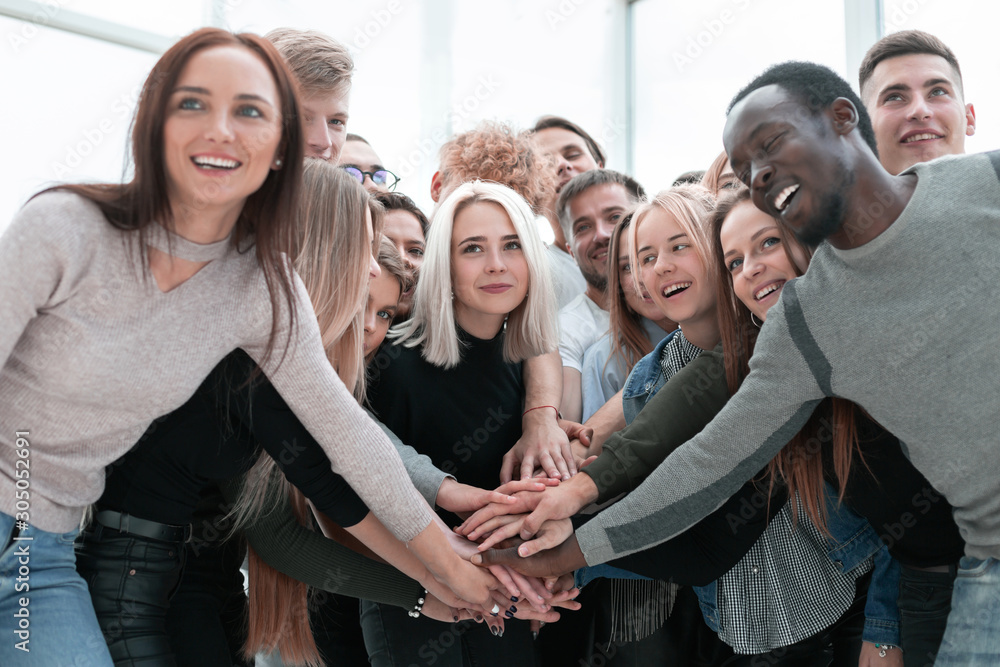 diverse young people putting their hands together