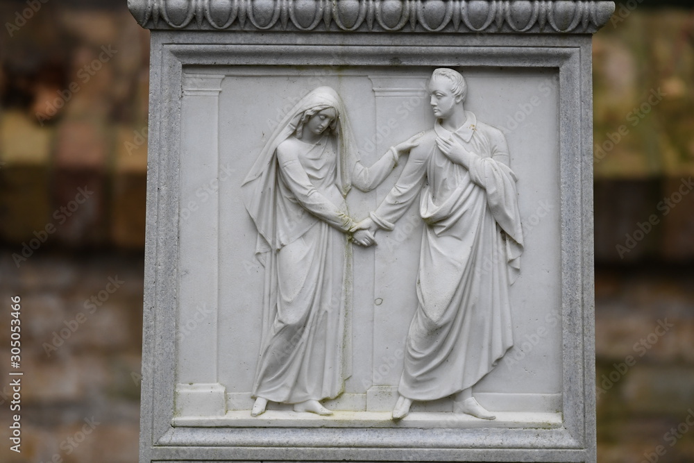 Fototapeta premium An old sandstone relief that shows a man who forgives a young woman.