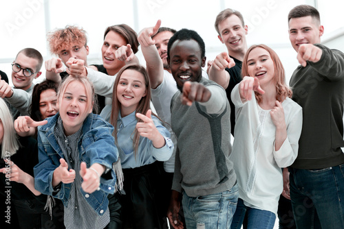 group of cheerful young people pointing at you